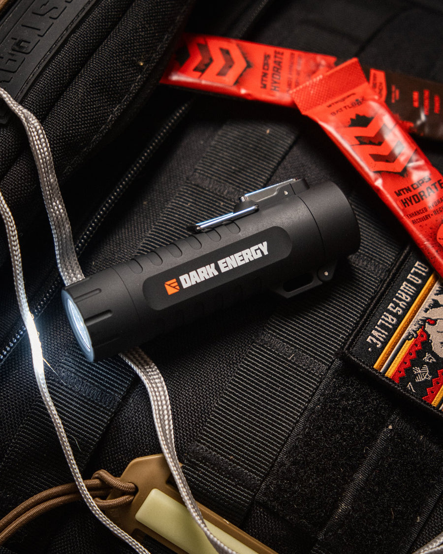 Dark Energy flashlight resting on a pack