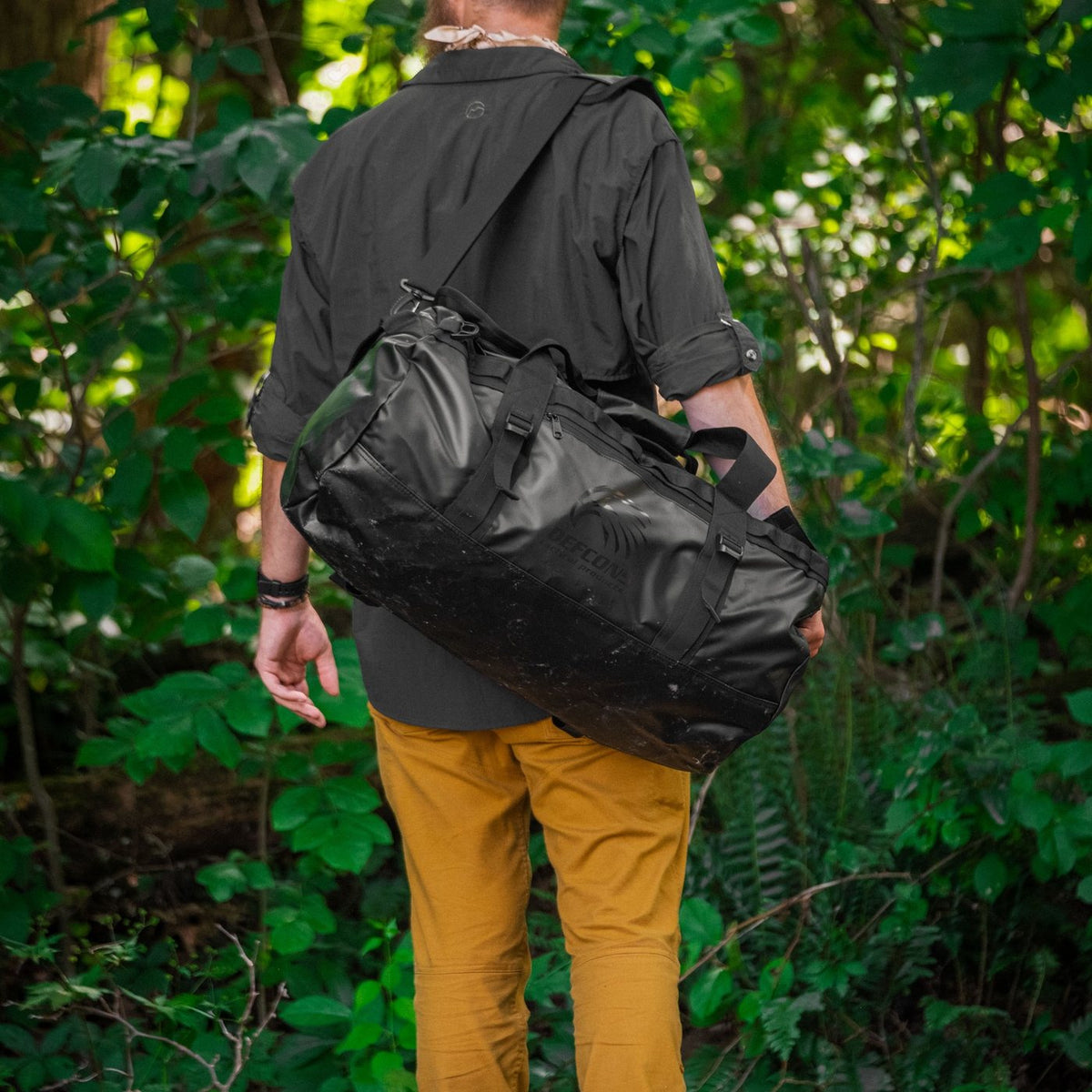 BattlBox member carrying the free Defcon 5 duffle through the woods