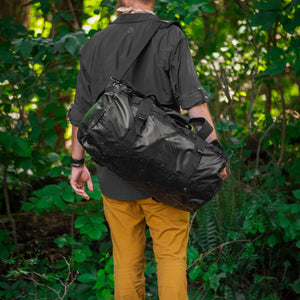 BattlBox member carrying the free Defcon 5 duffle through the woods